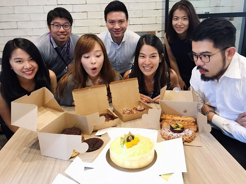 Group of young people blowing out candles on a cake